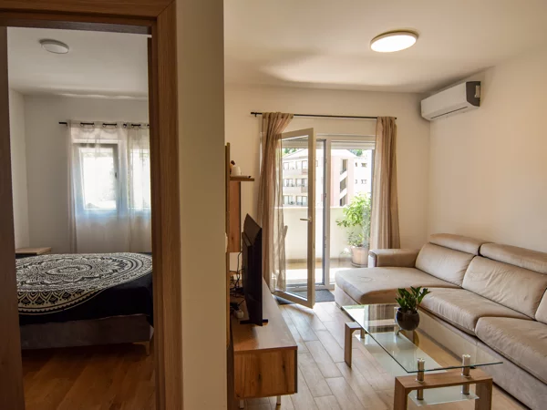Open-plan living room with sofa and balcony access, Plumeria Loft Budva